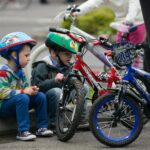 children riding on red mountain bike during daytime